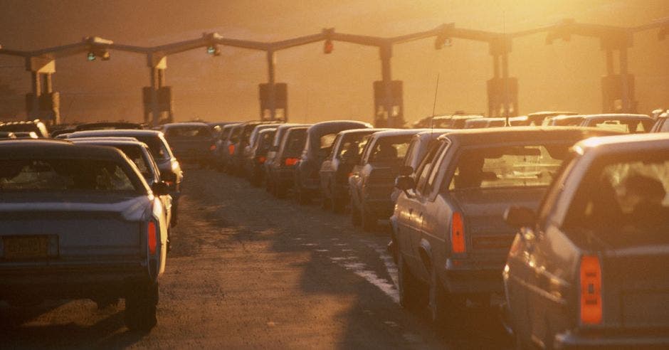 autos haciendo fila para caseta de cobro