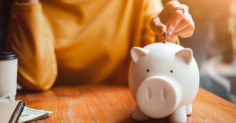 Persona depositando dinero en alcancía