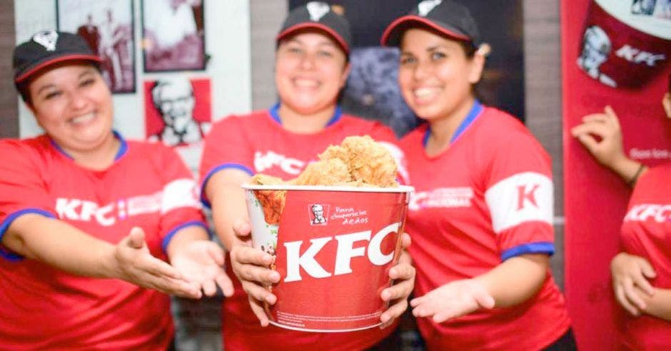 Personal de KFC con bucket de pollo