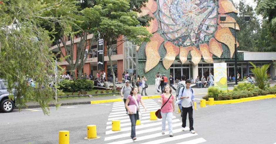 estudiantes cruzando un paso peatonal en una universidad