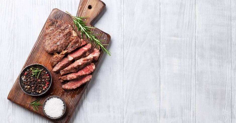 una tabla de madera con carne recién cortada