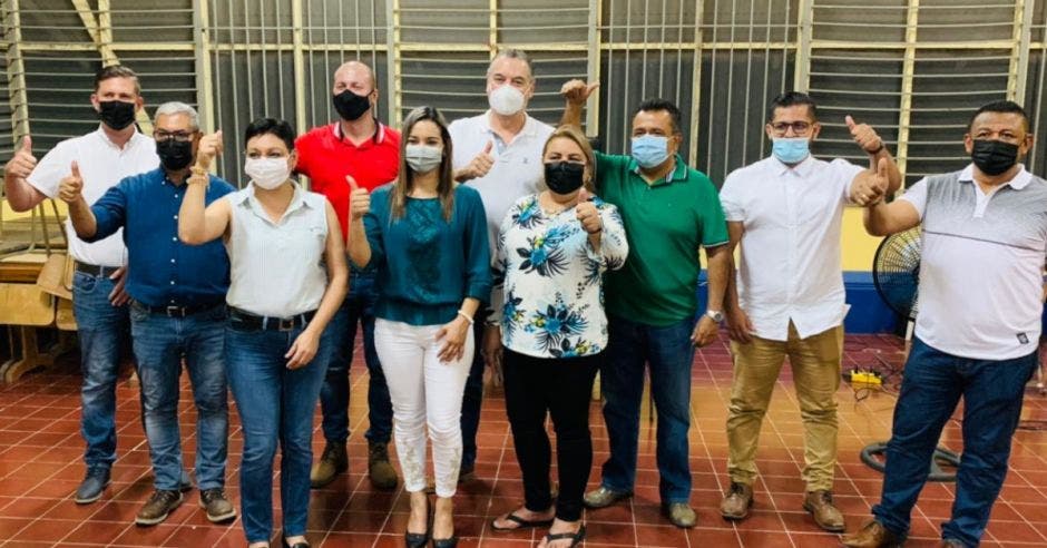 personas con mascarilla levantando el pulgar