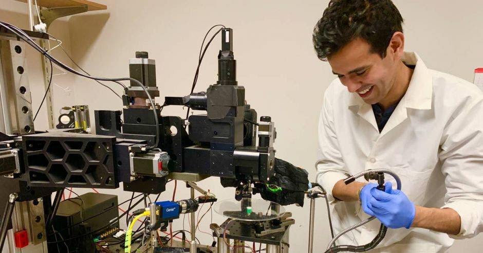 un hombre con bata manipula equipo de laboratorio