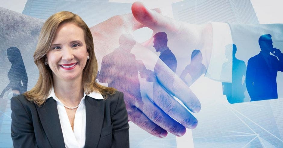 una mujer sonriente sobre un fondo de personas dándose la mano