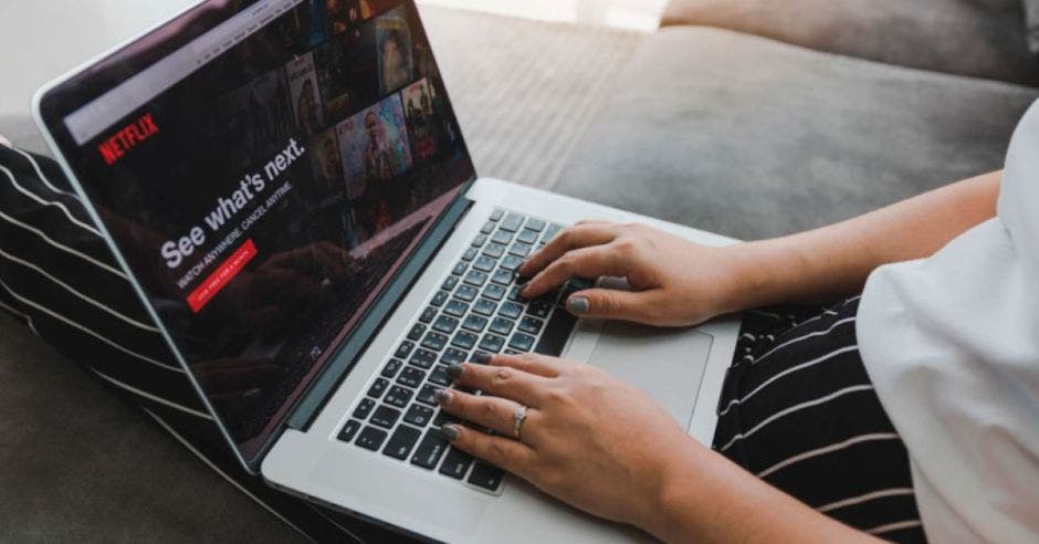 mujer sentada viendo Netflix en laptop