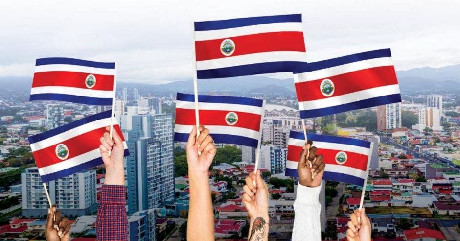 manos levantadas con banderines de Costa Rica de fondo ciudad de San José