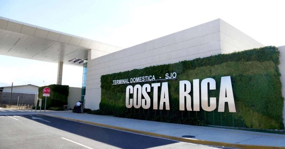 una terminal aeroportuaria con un letrero grande que dice Costa Rica en letras plateadas