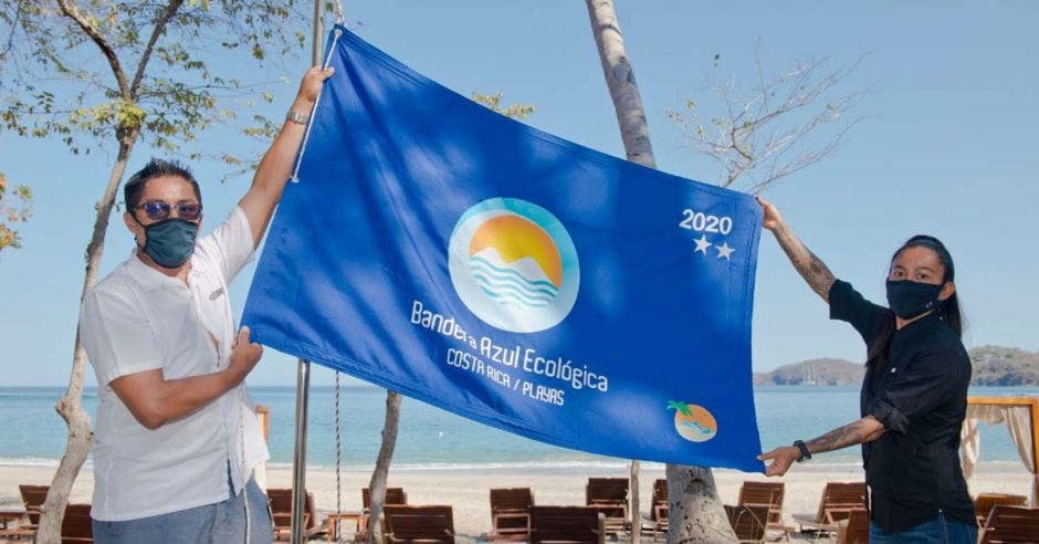 una bandera azul sostenida por dos personas