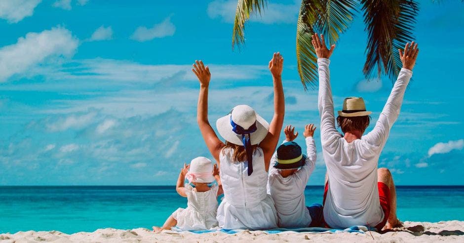 Familia de blanco sentada en la playa