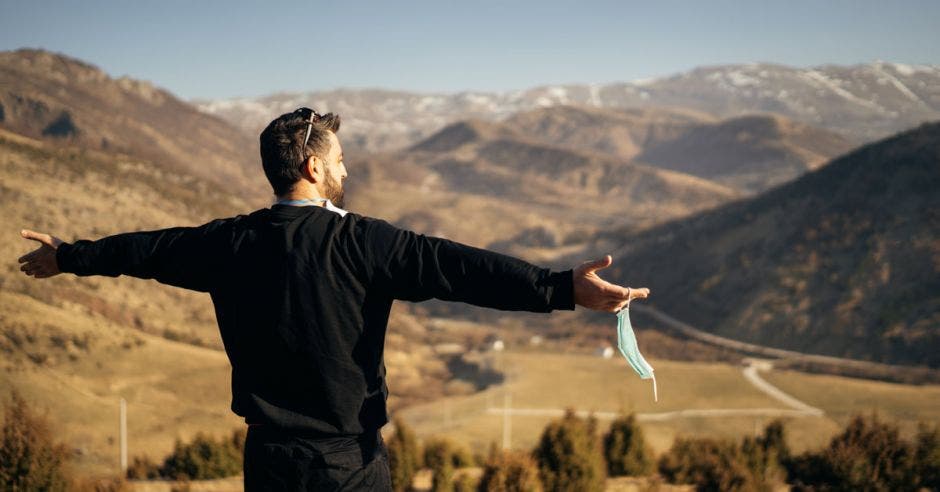 un hombre respira aire fresco en la cima de una montaña