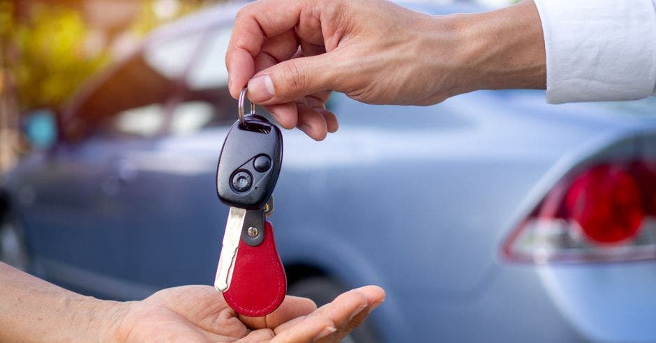 Mano dando llaves de carro a otro