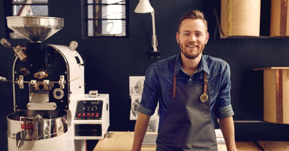 joven empresario junto a máquina de café