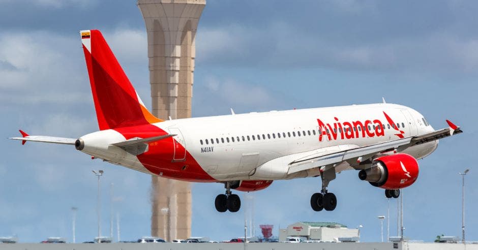 un avión blanco con rojo despegando