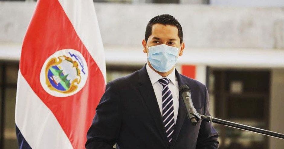 un hombre joven de saco y corbata usando mascarilla