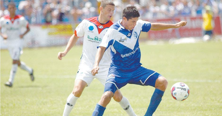 Dos jugadores de futbol luchando por el balón