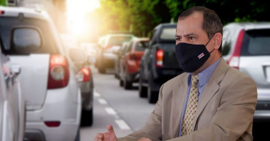 un hombre con mascarilla sobre un fondo de automóviles