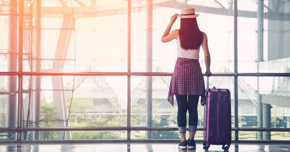 una mujer en el lobby de un aeropuerto, esperando su avión