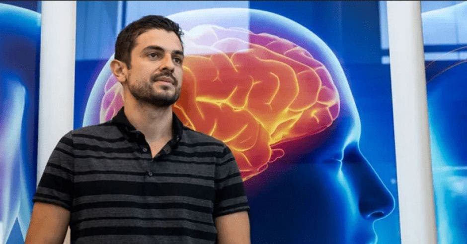 un hombre con una camisa polo a rayas sobre un fondo de un cerebro brillando