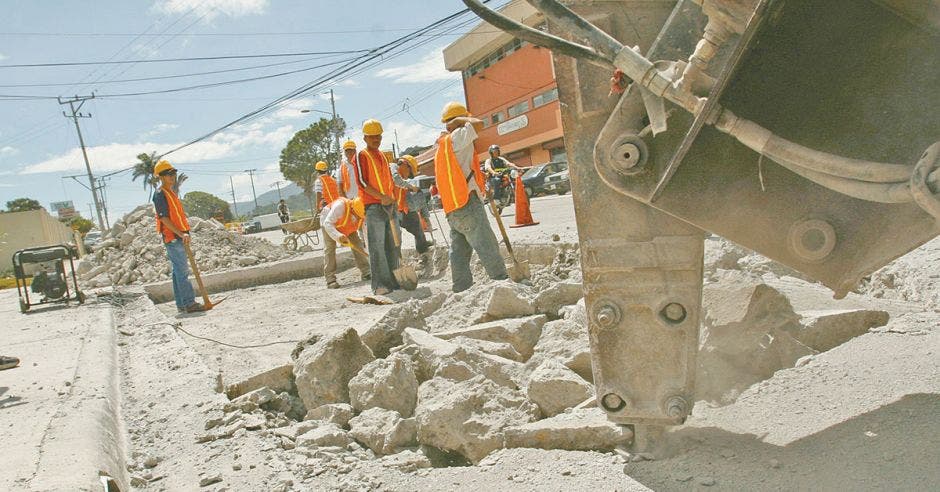 Hombres y maquinaria realizando trabajos de reparación en la carretera