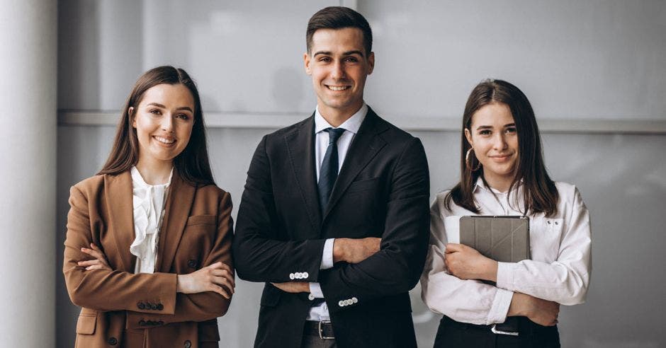 hombre de traje obscuro entre dos mujeres ejecutivas