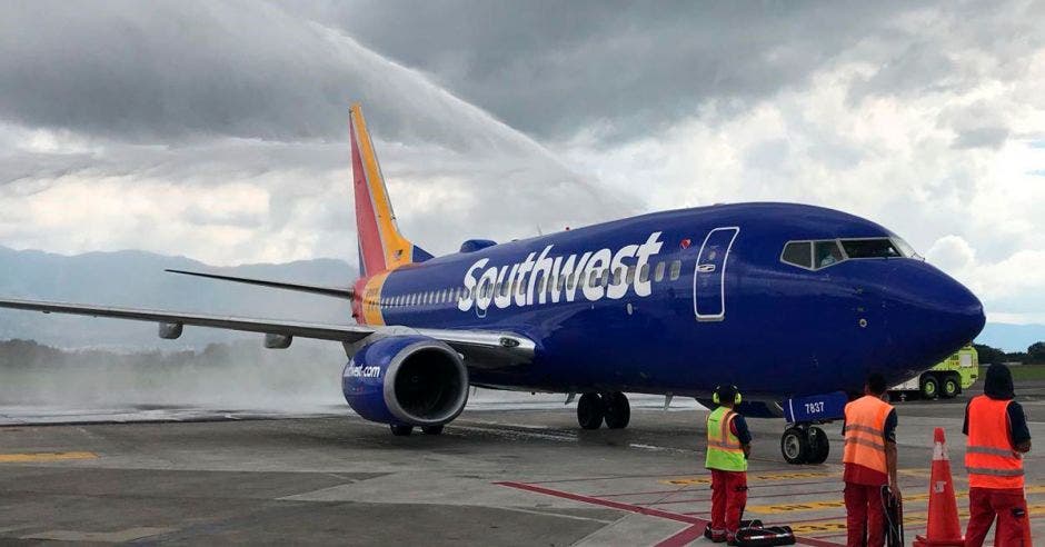 Un avión azul en una pista de aterrizaje