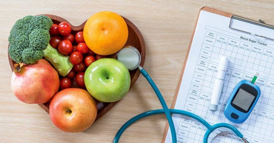 Frutas y verduras y un estetoscopio y herramientas de monitoreo médico