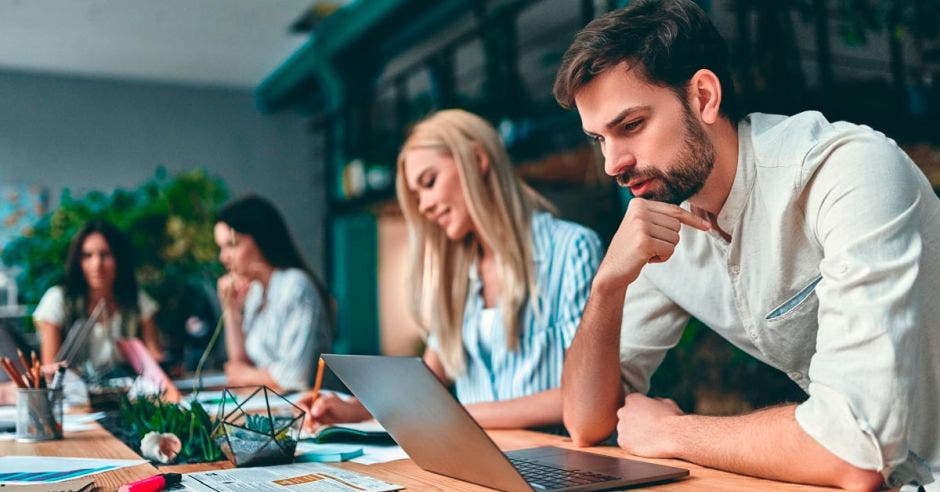 Grupos de jóvenes empresarios trabajan juntos en oficinas modernas. Personas creativas con laptop, tablet, smartphone, portátil.