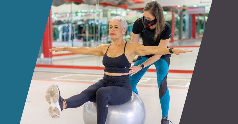 adulta mayor sobre balón ejercicio instructora gimnasio