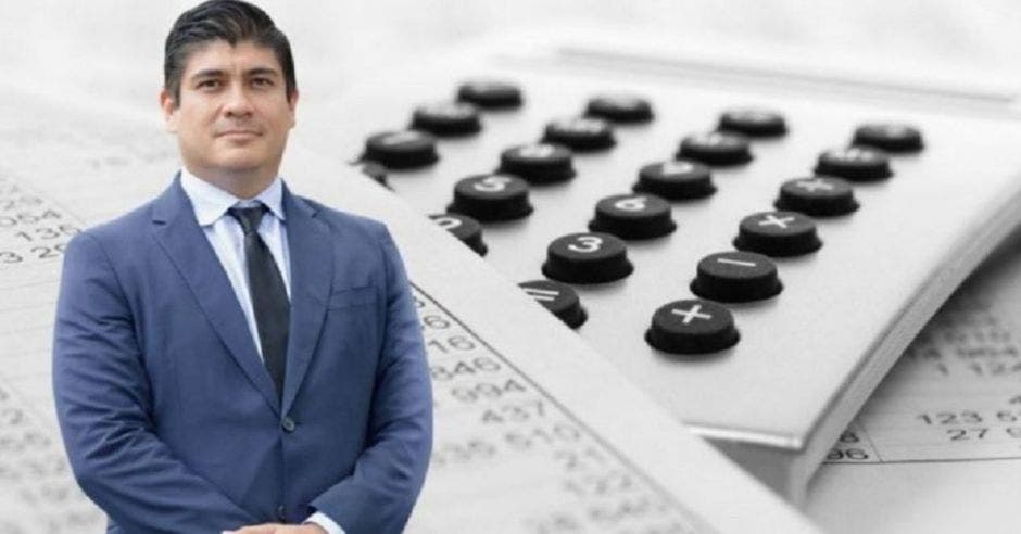 Carlos Alvarado de traje frente a calculadora