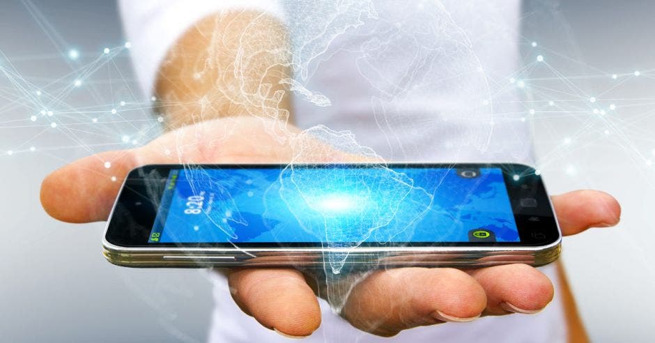 un hombre sostiene un celular con una imagen en 3d del continente americano