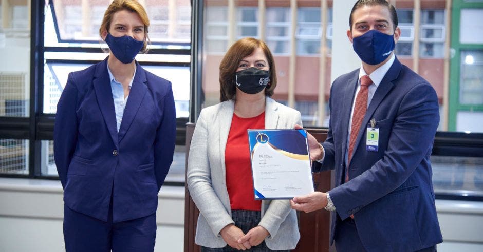 mujeres y hombre con mascarilla recibiendo certificación