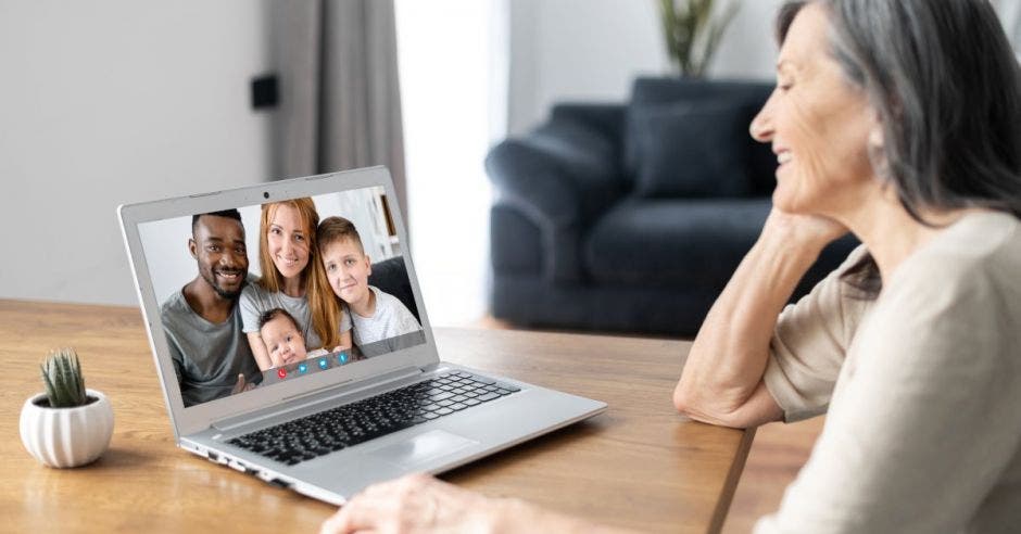 Mujer frente a computadora con imagen de familia