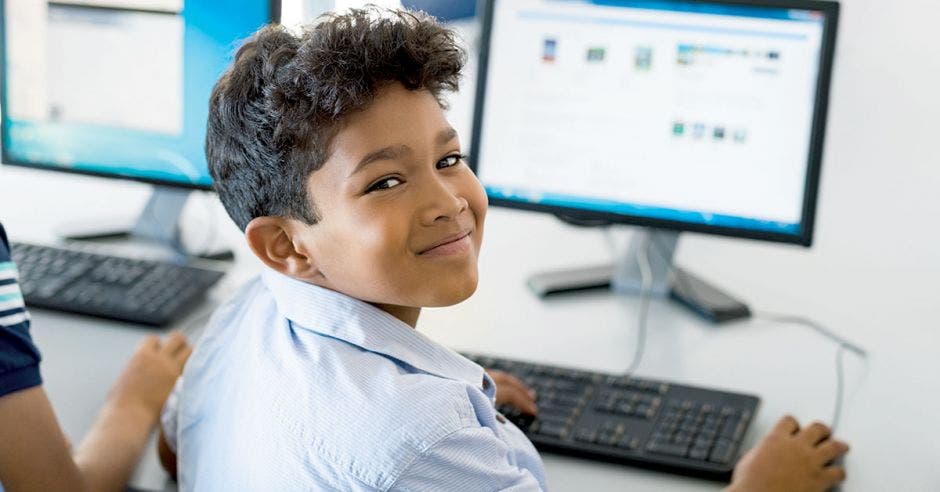 Joven de colegio utilizando una computadora.