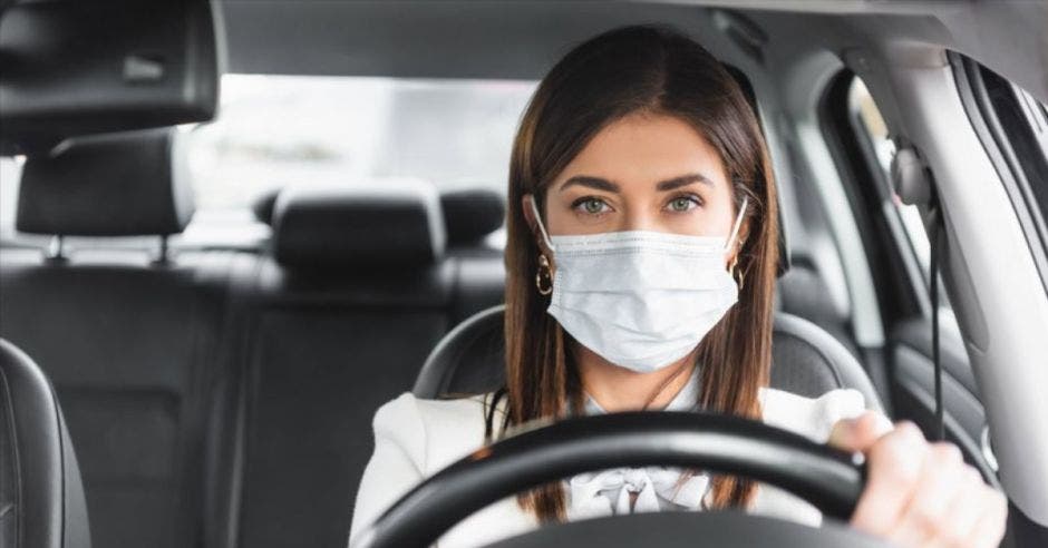 mujer con mascarilla manejando