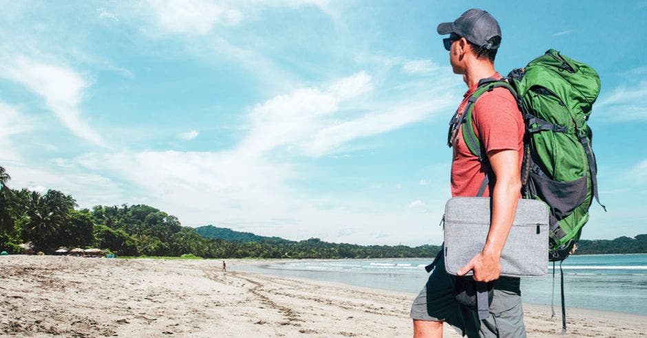 un hombre con varias maletas de viaje sobre una playa