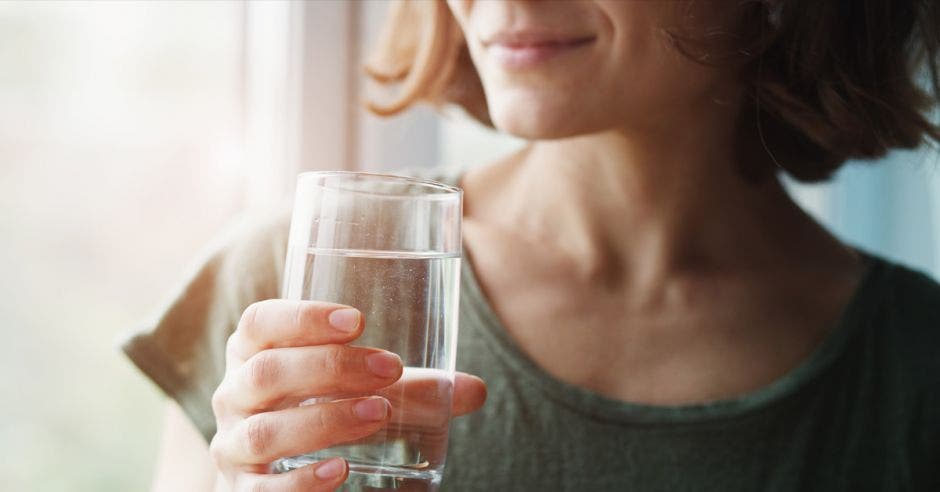 mujer joven saludable sosteniendo un vaso de agua