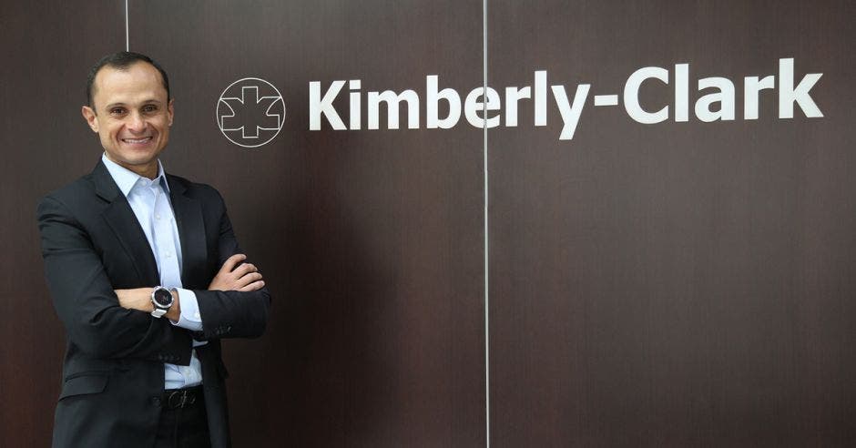 un hombre de traje sobre un fondo café que dice kimberly clark