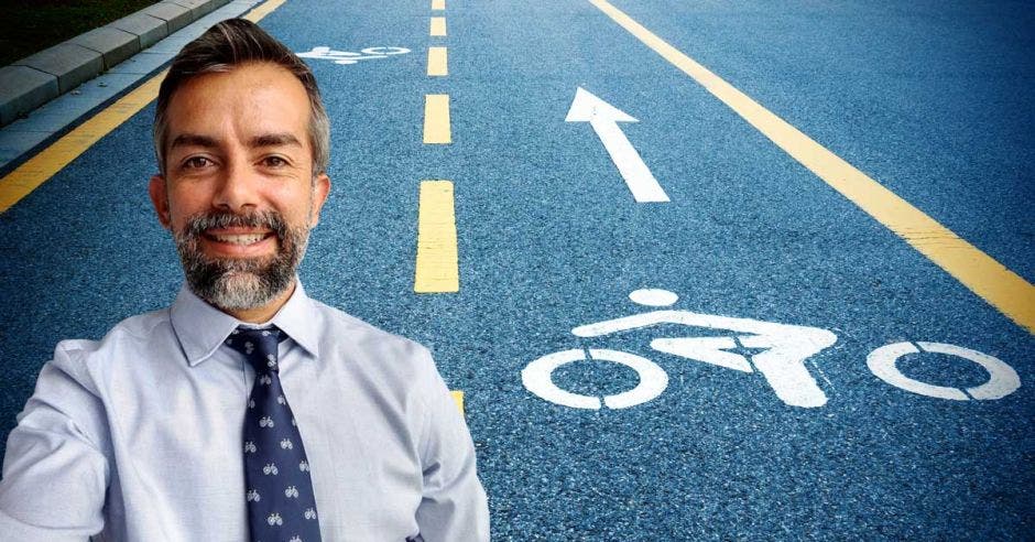 un hombre de corbata y barba sobre el fondo de una ciclovía