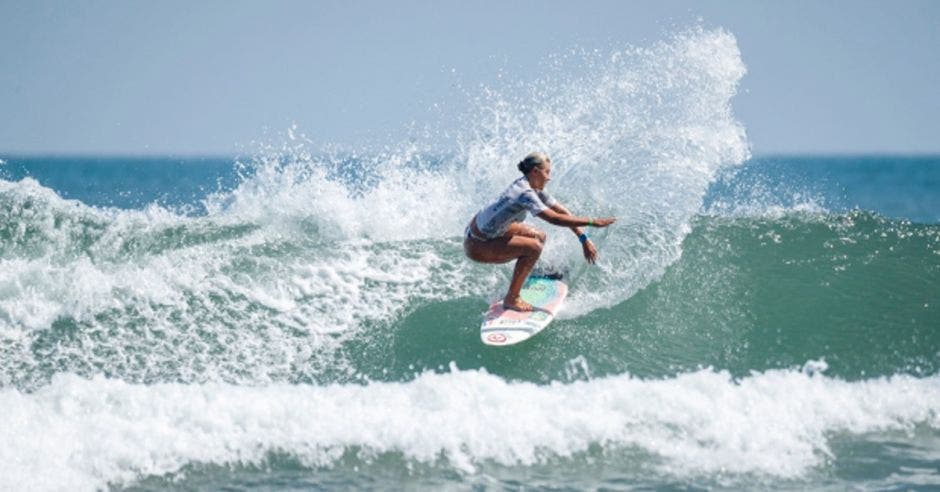 Mujer en tabla de surf en ola