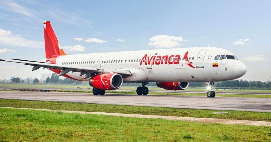 un avión blanco y rojo sobre una pista de aterrizaje