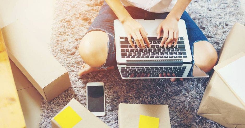 una mujer usando una computadora en la sala de su casa. Concepto de emprendedora.