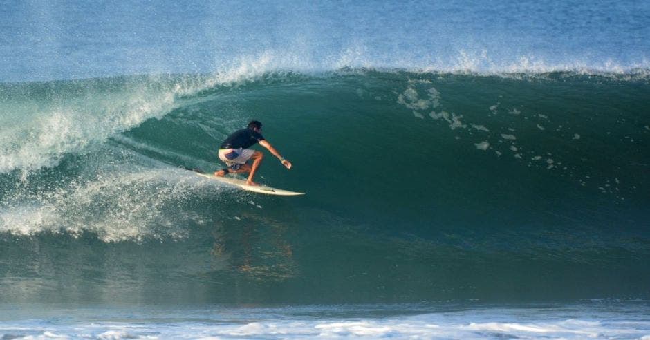 un hombre de camisa azul surfeando