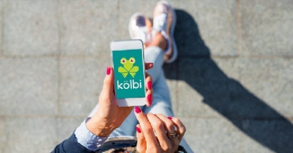 Mujer camina con un celular de kölbi