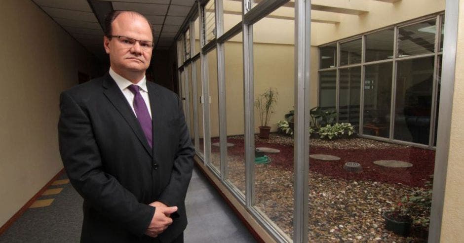 un hombre de saco oscuro y corbata morada