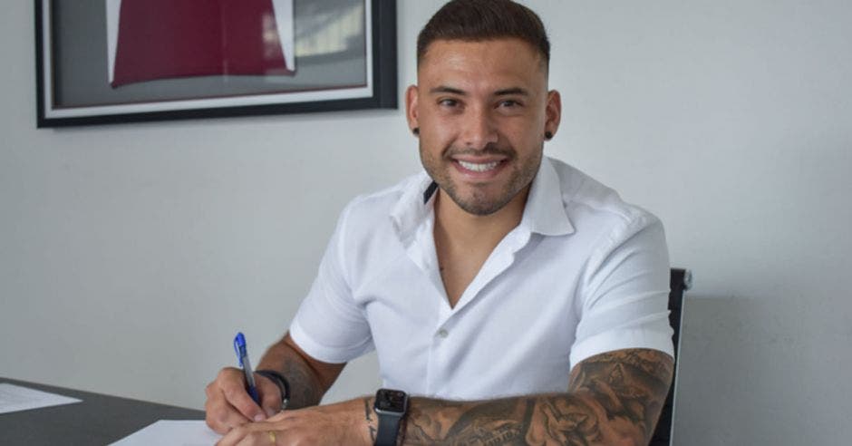 un hombre blanco con camisa blanca, barba y tatuajes