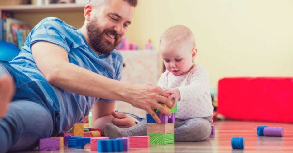 padre e hijo jugando en la sala con bloques de madera