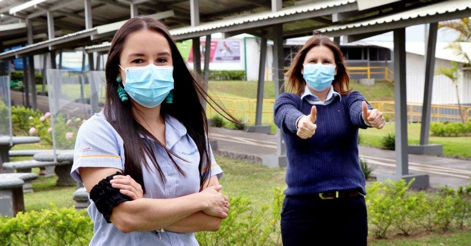 dos mujeres de camisas de azules mostrando el pulgar arriba