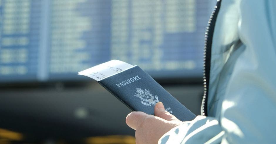 una persona sostiene un pasaporte de Estados Unidos en su mano