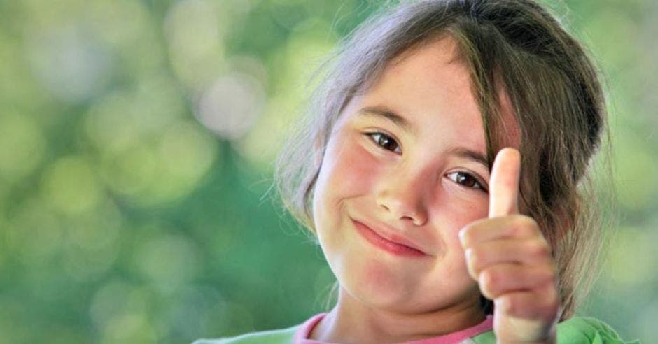 niña haciendo señal con pulgar hacia arriba