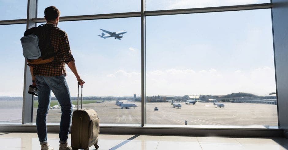 un hombre con equipaje en el lobby de un aeropuerto